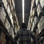 a man looking up at a tall warehouse racking