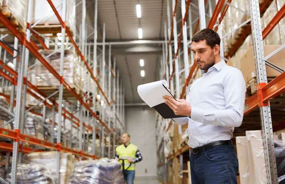 man in warehouse checking racking and load notices
